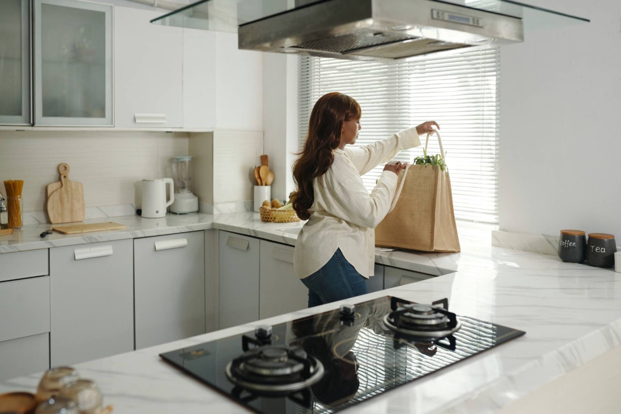 Someone standing in a kitchen with window blinds at Blinds and Shutters of All Kinds near Newhall, California (CA)
